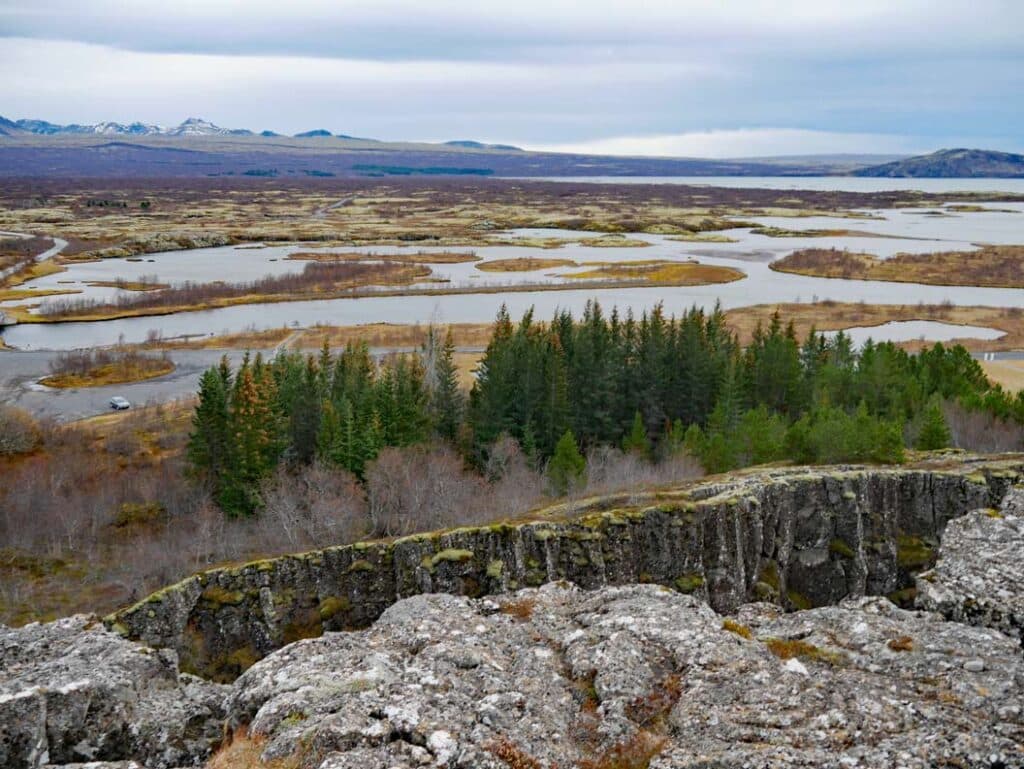 Golden Circle Island - 3+ Island Highlights auf einer Route aussicht-auf-den-see-im-thingvellir-nationalpark-vorne-felswaende-dahinter-tannen-und-dann-seelandschaft