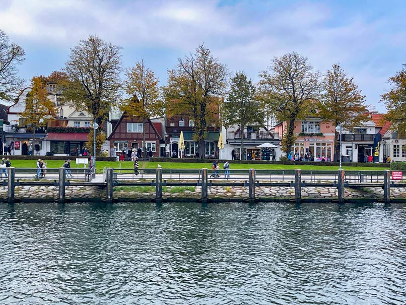 blick-ueber-den-alten-strom-in-warnemuende-auf-herbstliche-baeume-und-bunte-gibelhaeuser