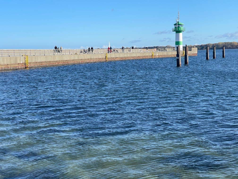 hellblaues-wasser-gruener-leuchtturm-in-travemuende