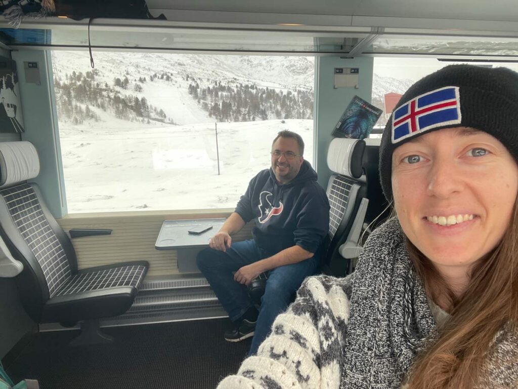 Bernina Express vs. Regionalbahn: Tipps für die perfekte Zugreise durch die Schweizer Alpen ehepaar-im-erste-klasse-abteil-der-regionalbahn-auf-der-bernina-express-strecke