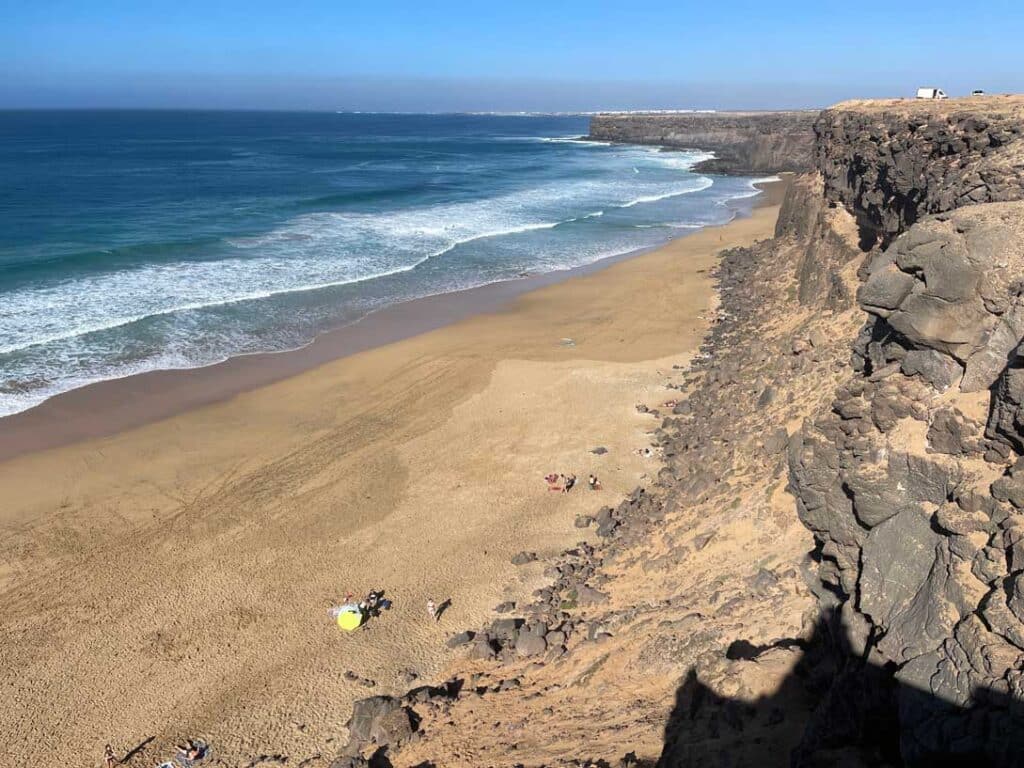 Unsere Top 11 Strände auf Fuerteventura blick-von-oben-auf-gelben-sandstrand-mit-hoher-felswand-auf-fuerteventura