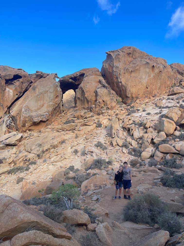 14+ Fuerteventura Sehenswürdigkeiten für den Familienurlaub mutter und sohn bei einer wanderung auf fuerteventura vor steinbogen