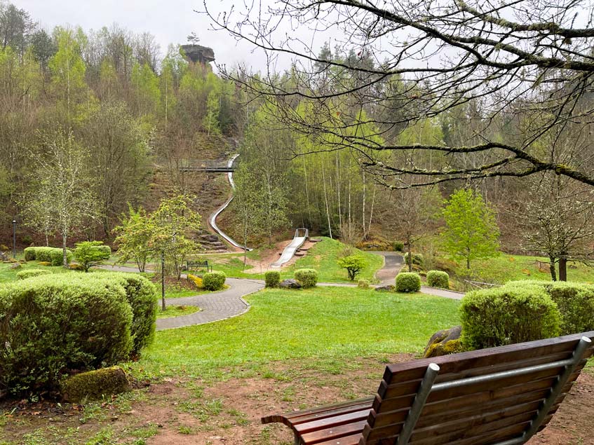 Wandern im Dahner Felsenland 🥾 7+ Tipps spielplatz auf grüner wiese mit langer rutsche im hintergrund teufelstisch