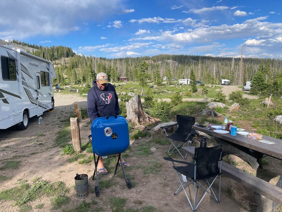 mann grillt auf campingplatz im national forest in den usa