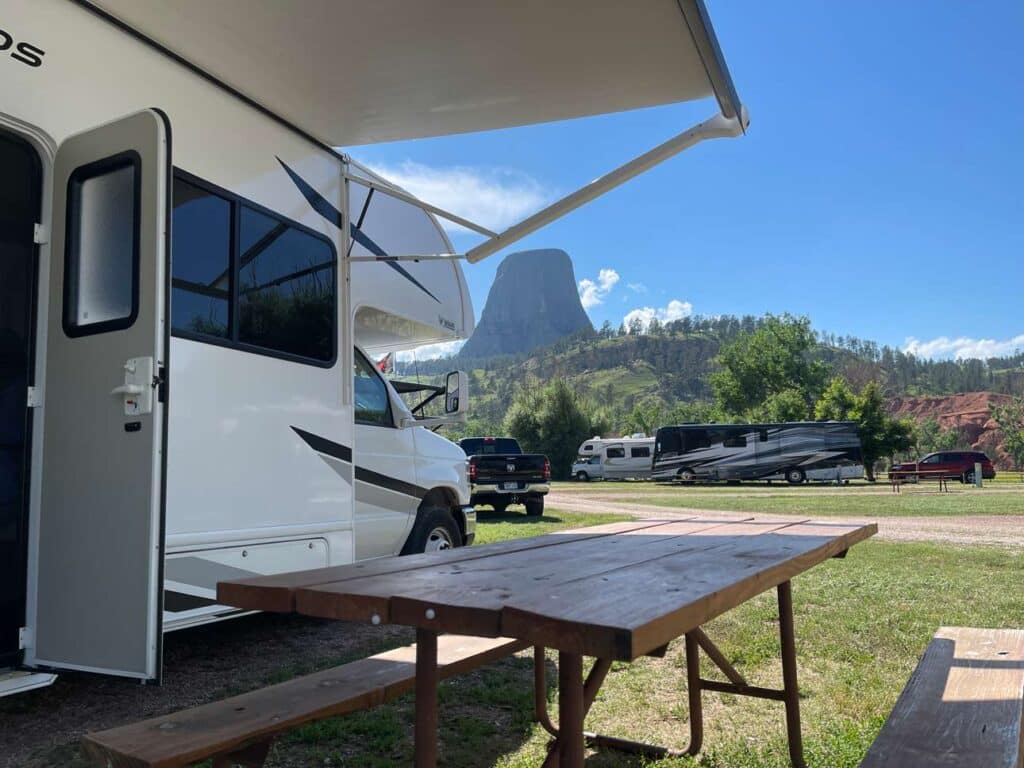 USA Rundreise Denver - mit Yellowstone Nationalpark wohnmobil mit markise im hintergrund devils tower