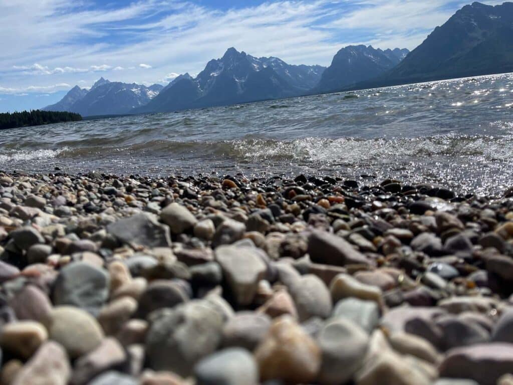 steiniger strand an der colter bay mit blick auf grand teton