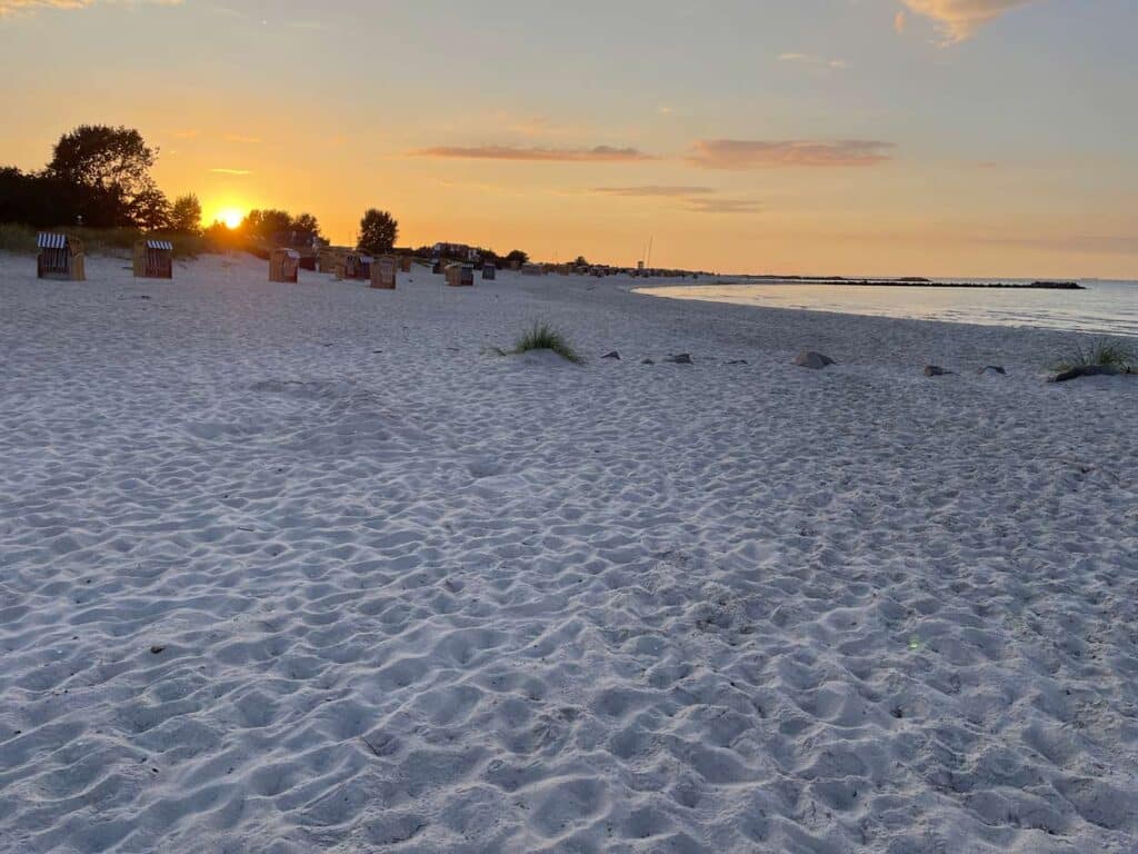 sonnenuntergang an weißem sandstrand an der ostsee