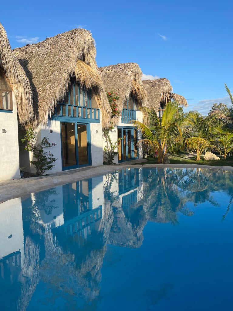 weiße häuschen mit strohdach und pool in der dom rep