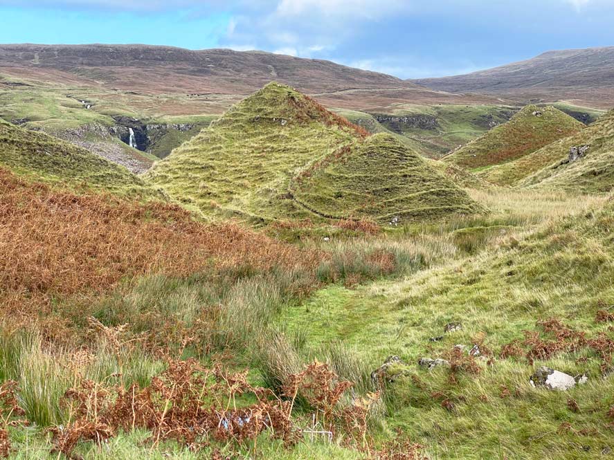 fairy glen hügelige landschaft auf skye wasserfall im hintergrund