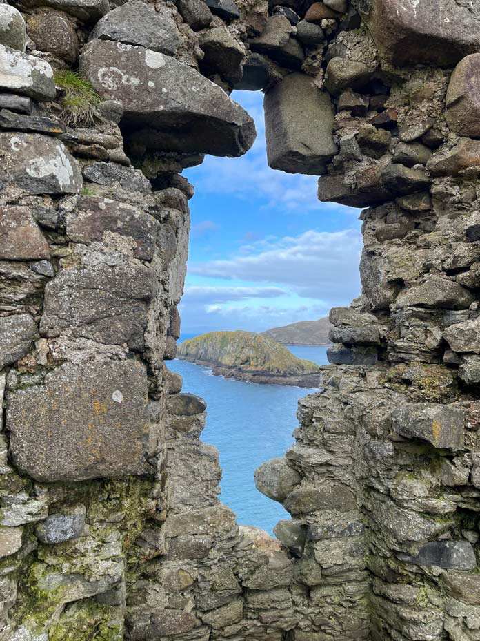 blick aus ruinen fenstern des duntulm castle auf insel im meer