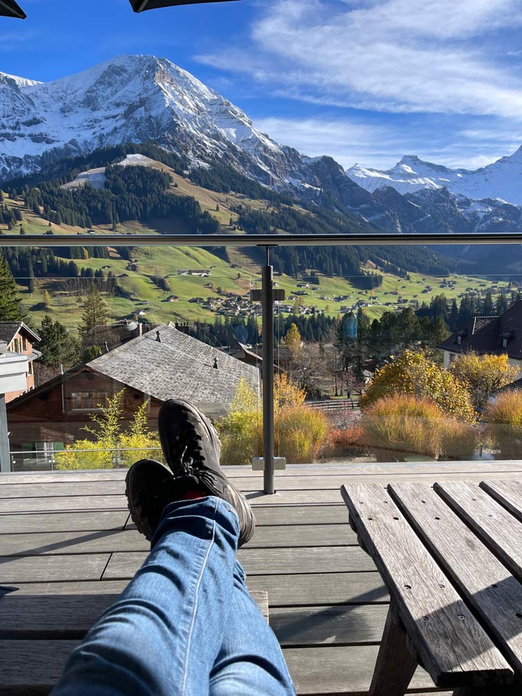hochgelegte beine in wanderschuhen mit blick auf berge im hotel the cambrian