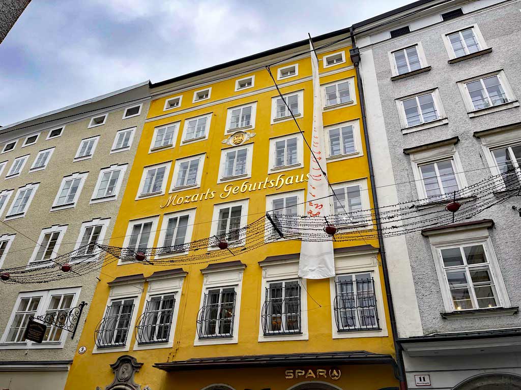 gelbes haus in salzburg mit der aufschrift mozarts geburtshaus