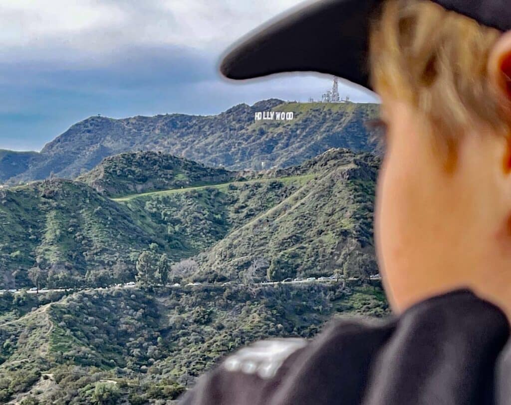 kind blickt auf hollywood sign in los angeles