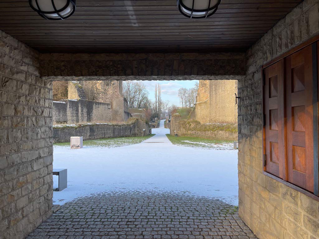 blick durch geschlossenes tor auf amphitheater trier im schnee