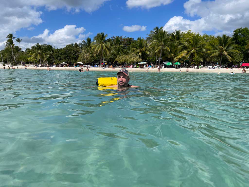 mann mit wasserdichtem rucksack im karibischen meer