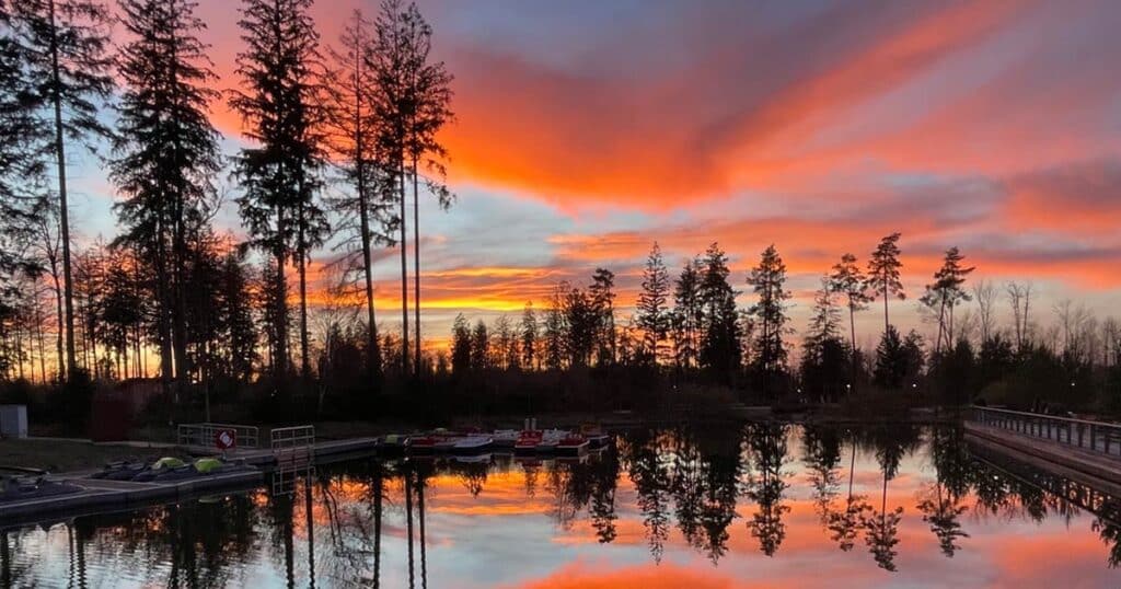 sonnenuntergang mit rotem himmel am see im center parcs allgäu