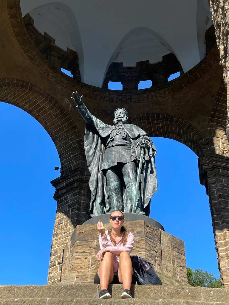 frau sitzt vorm kaiser wilhelm denkmal