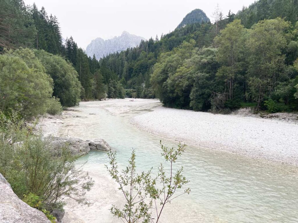 weisses flussbett der pisnica in slowenien mit bergen im hintergrund