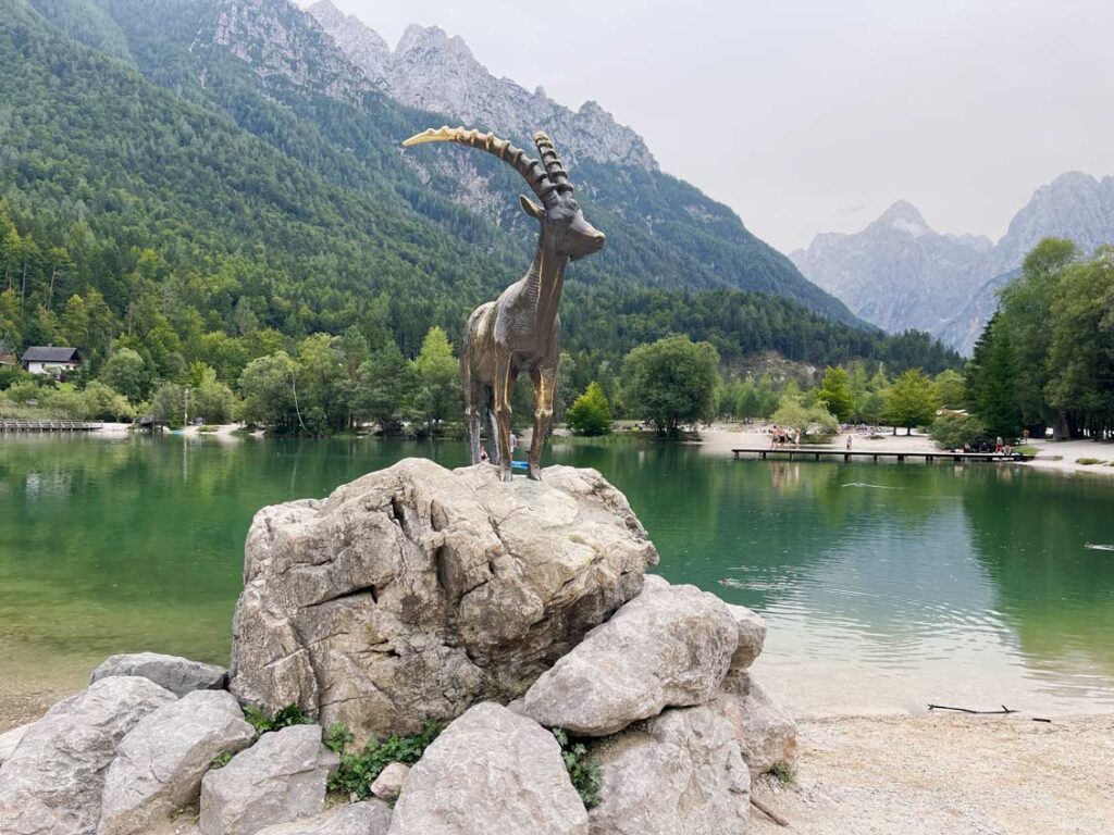 statue ziege auf steinen am jasna see in slowenien